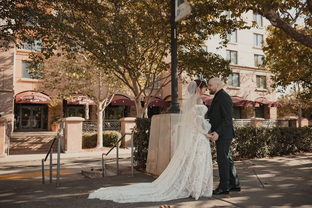 Bride and groom share an intimate moment outside a historic stone building with fall foliage overhead for Sacramento wedding first look