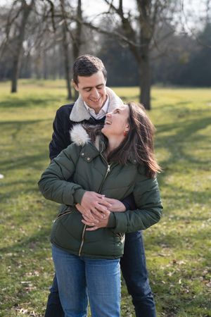 Couple enlacé dans un parc, sourire et regards tendres, à Rueil-Malmaison