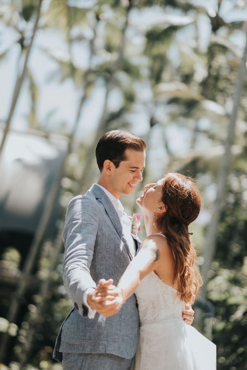 Couple dances together in bright tropical garden setting.