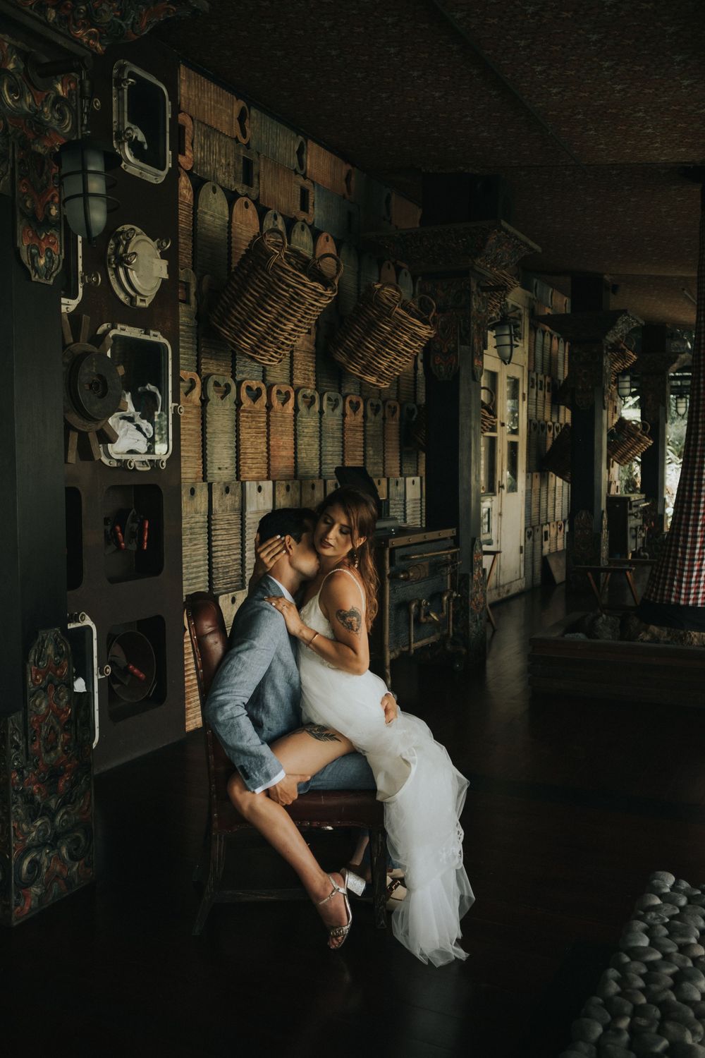 Romantic dance poses in dimly lit vintage room with rustic wall decorations.