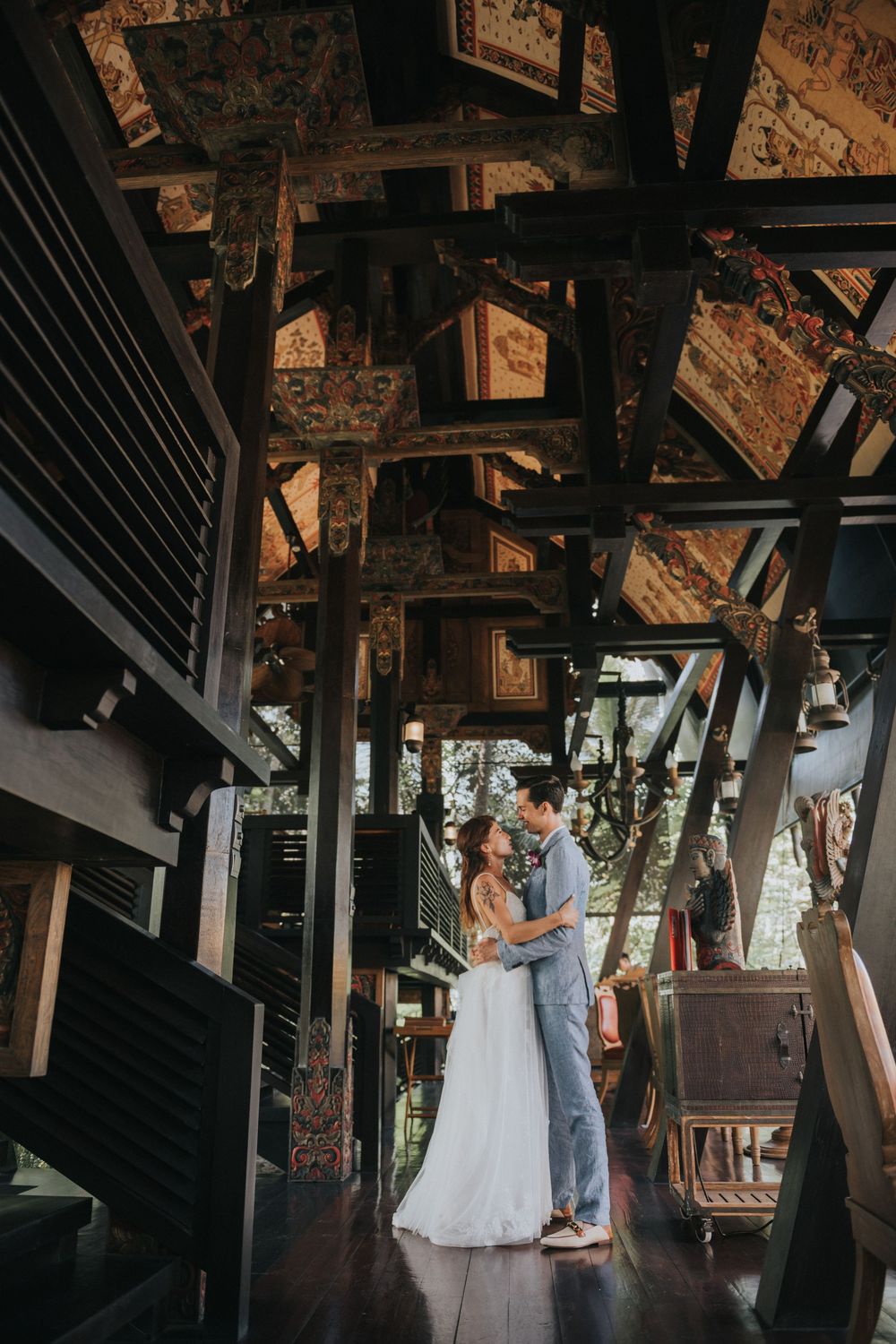 Couple shares intimate moment under wooden beams in rustic indoor setting.
