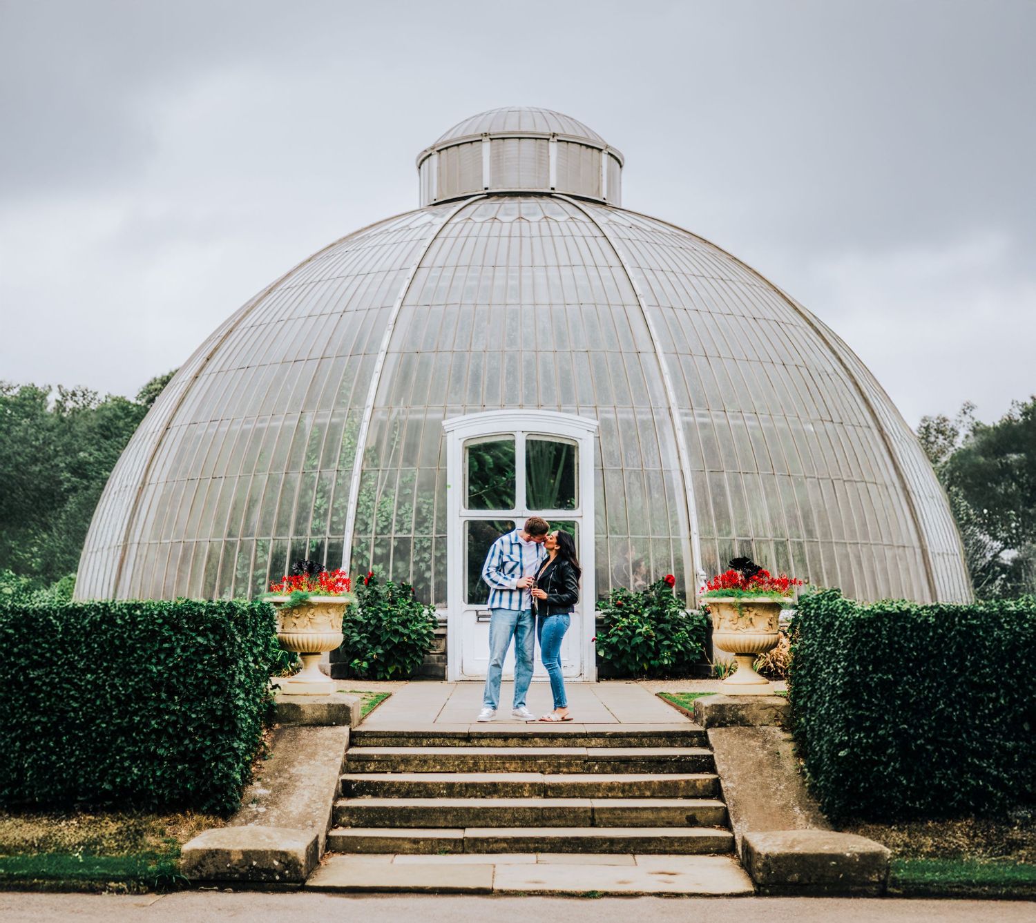 A historic domed glass greenhouse with ornate stone steps and manicured hedges shot from multiple angles in soft lighting.