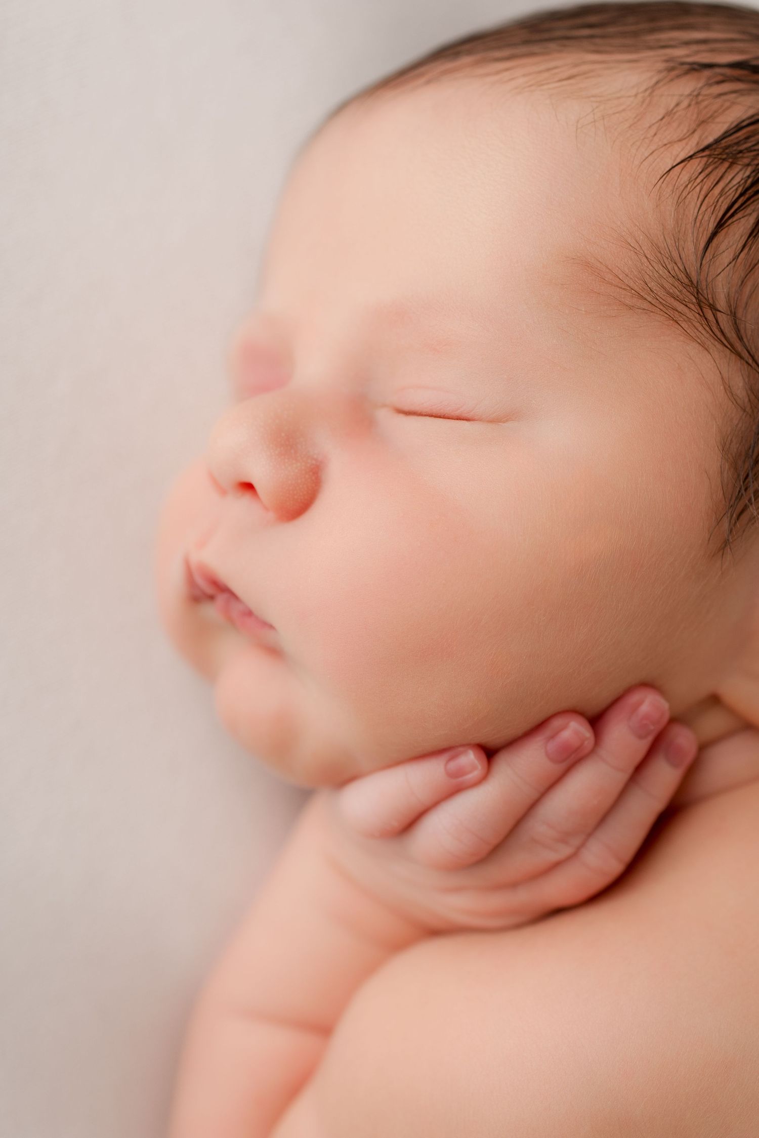 Close-up profile view of sleeping baby's face showing peaceful expression.