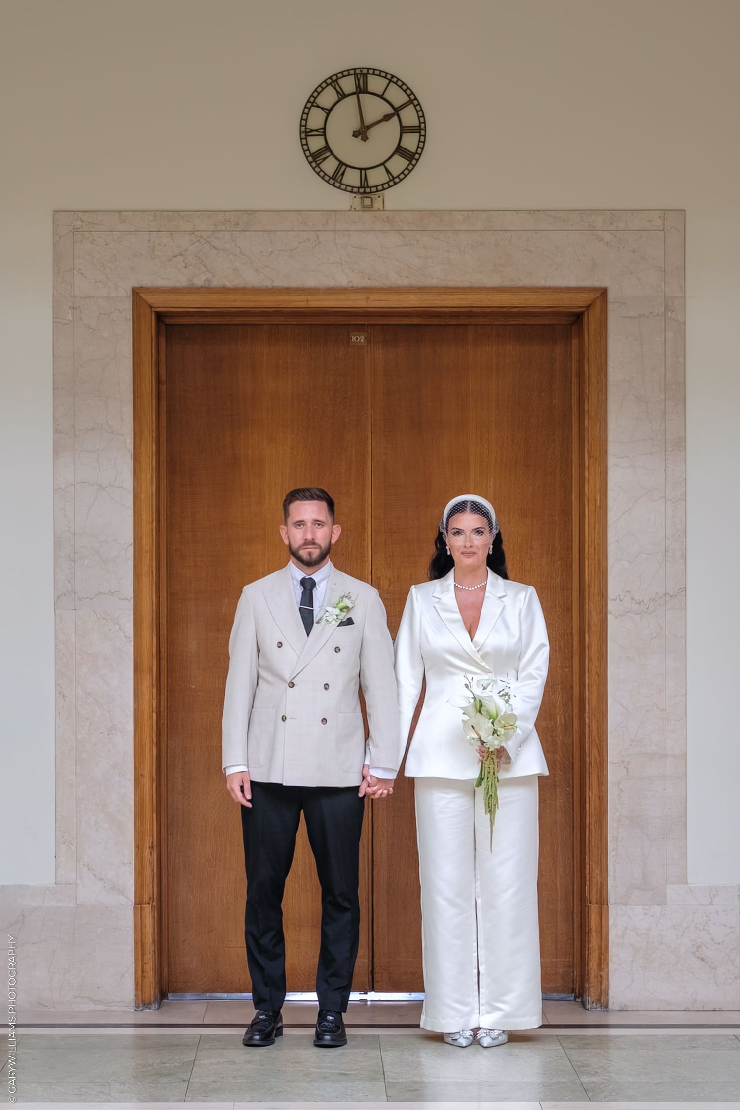Creative wedding photo series showing couple peeking out from wooden doorway in minimal architectural setting.