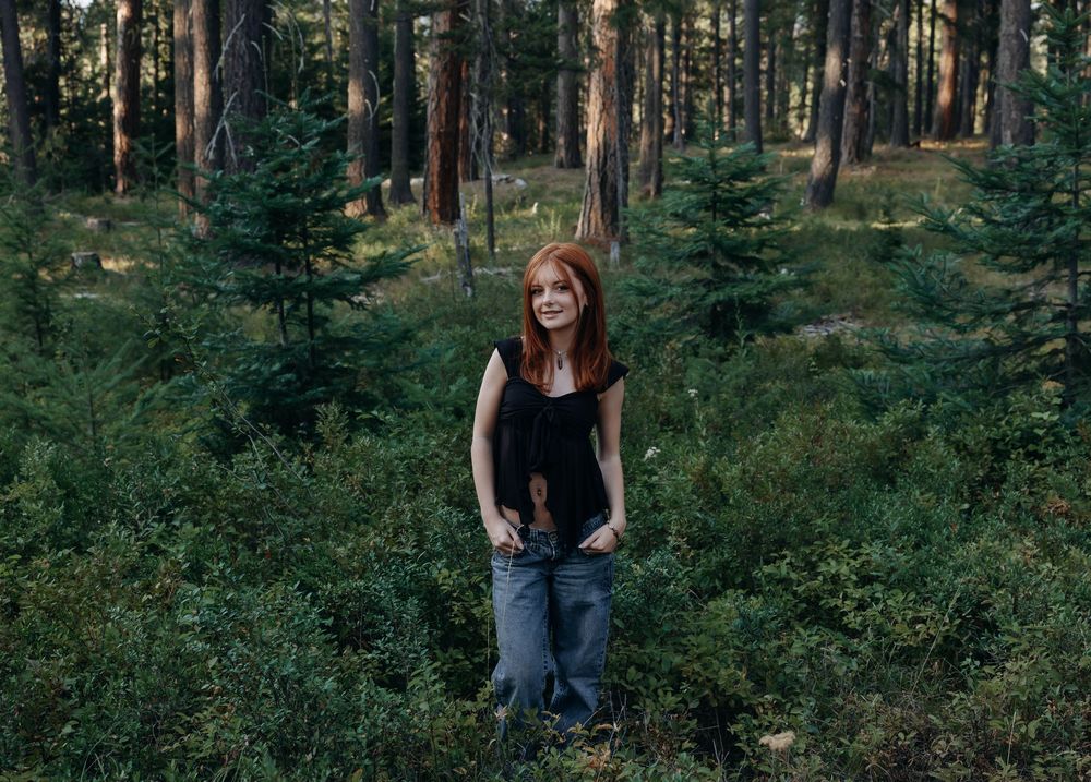 Pine trees and evergreen forest create a natural backdrop for an outdoor portrait session.