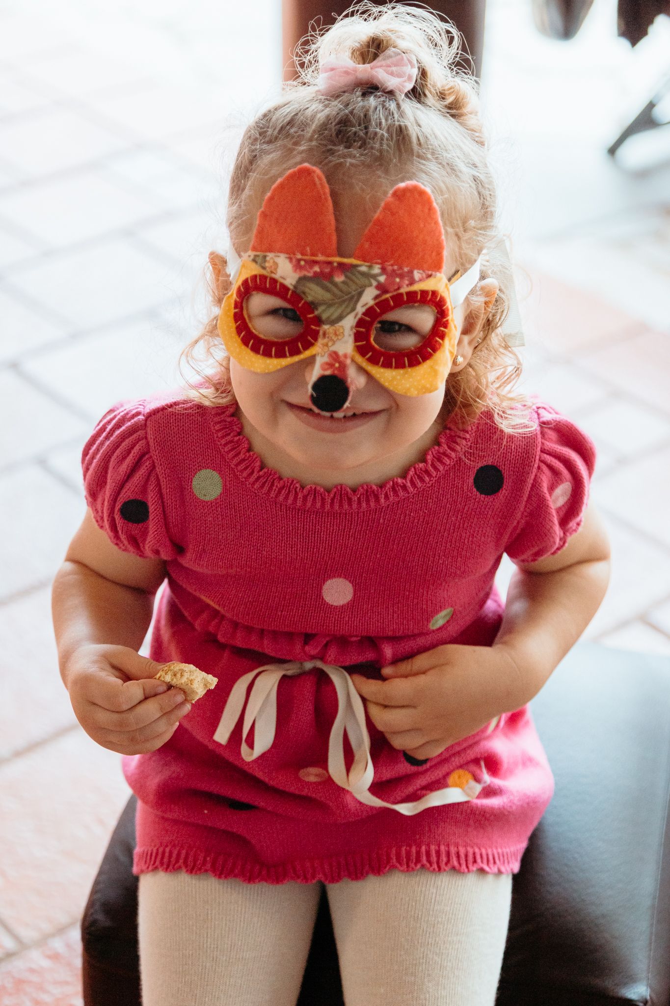 A small child in a pink polka dot top poses playfully in a series of close-up shots.