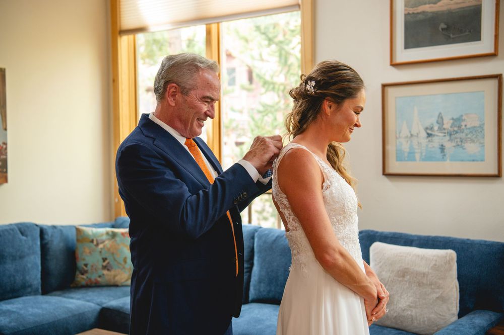 A bride and groom share a loving look as they dance together in a room filled with natural light.