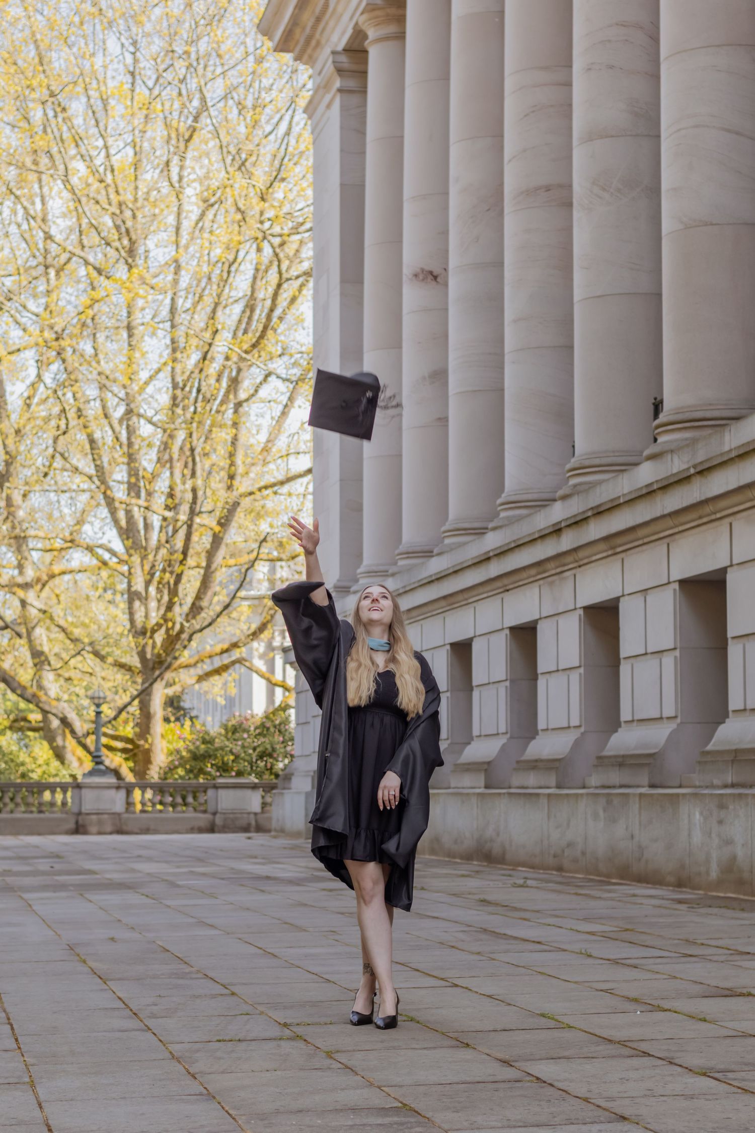 college graduate in black cap and gown pictured outside washington state capitol campus taken by olympia photographer