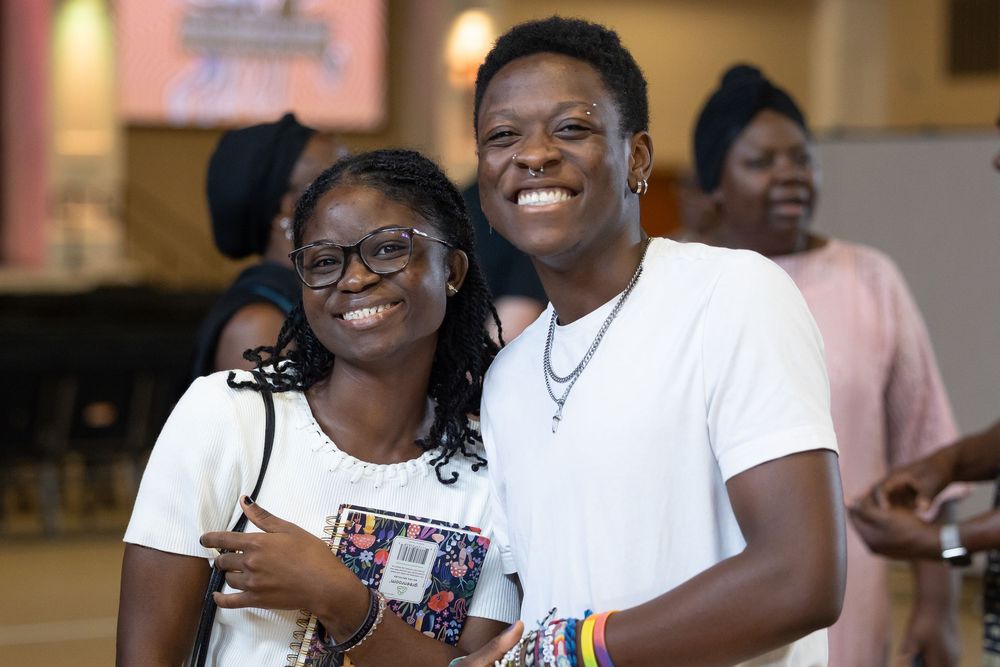 two young people smiling and hugging