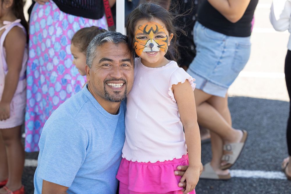 child and her parent at a festival
