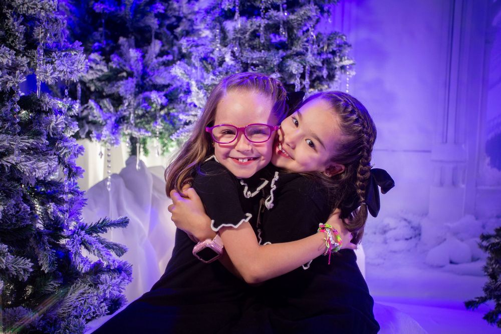 A couple shares a joyful moment during a winter wedding celebration surrounded by purple lighting and snowy decorations.