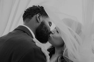 A tender black and white photo of a couple sharing an intimate moment during their wedding ceremony.
