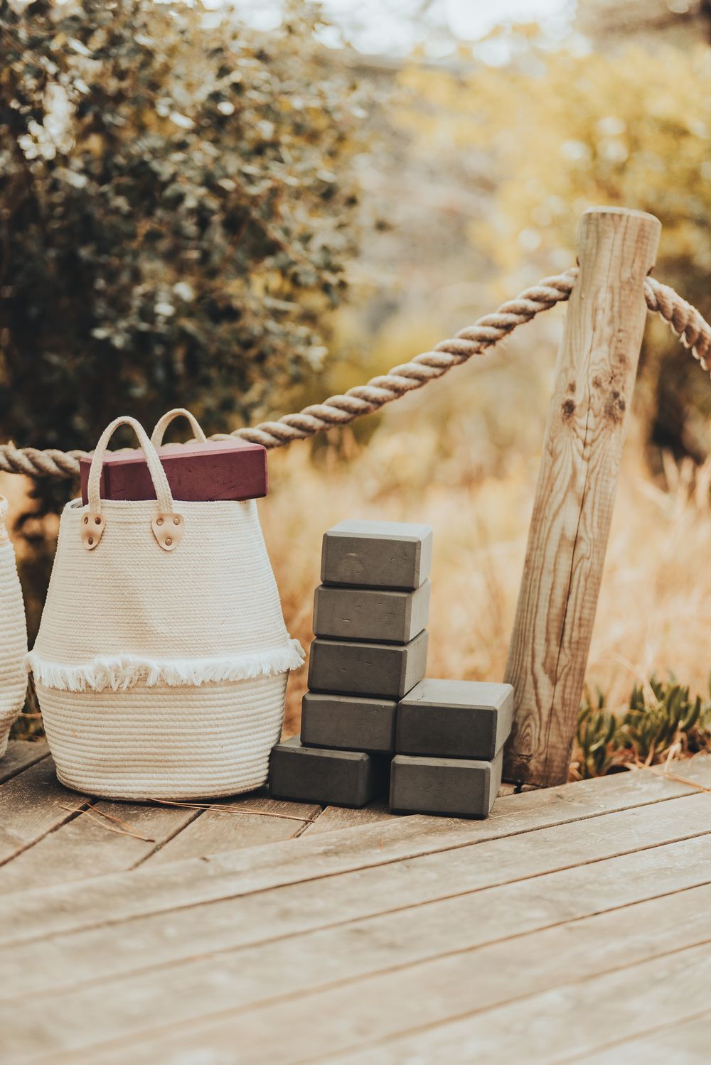 Woven basket and wooden boxes arranged on rustic deck in warm lighting.
