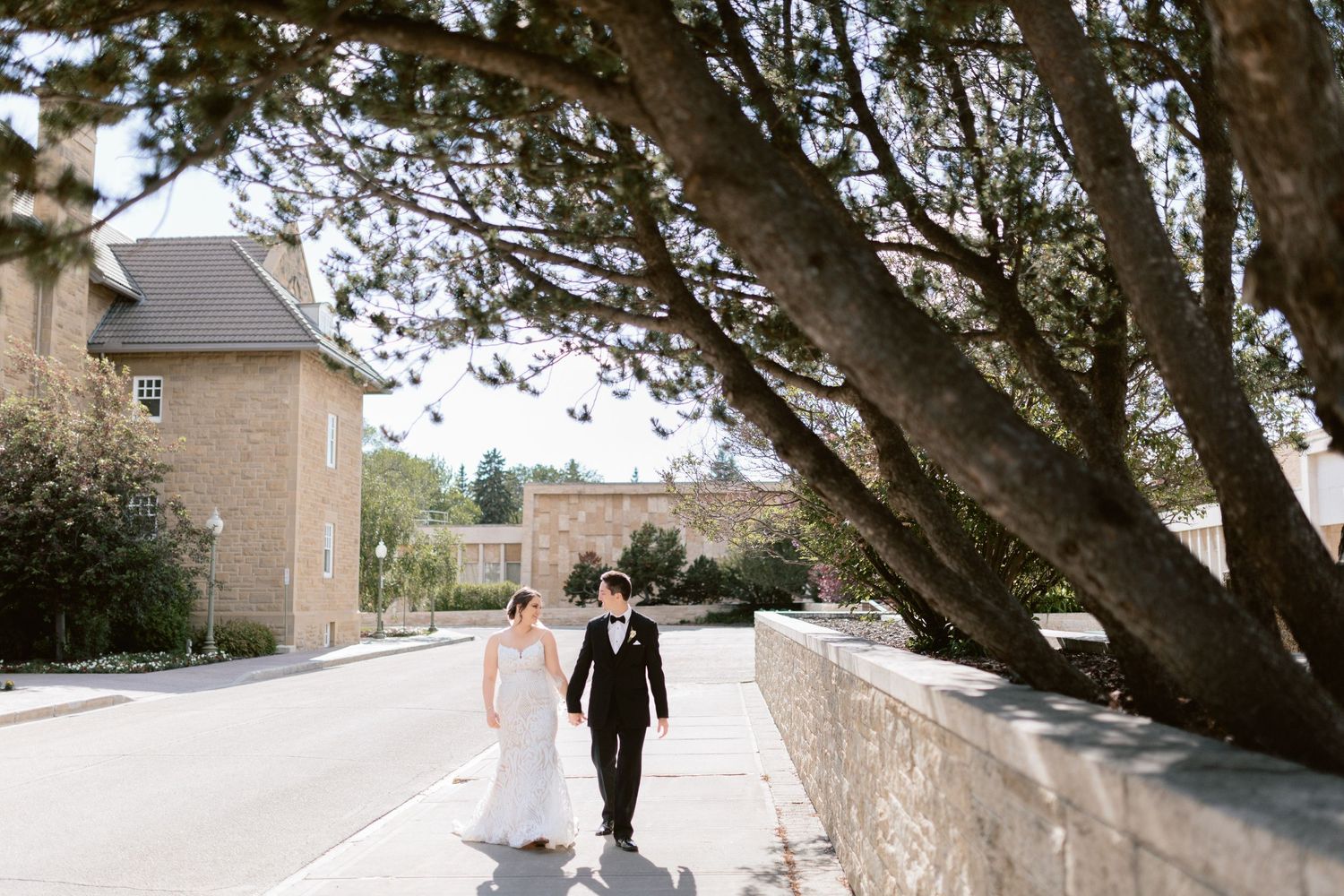 Wedding Photographer - Bride and groom hand in hand walking through museum grounds