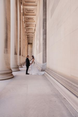Elegant architectural wedding photos with columns creating leading lines. Ohio State House.