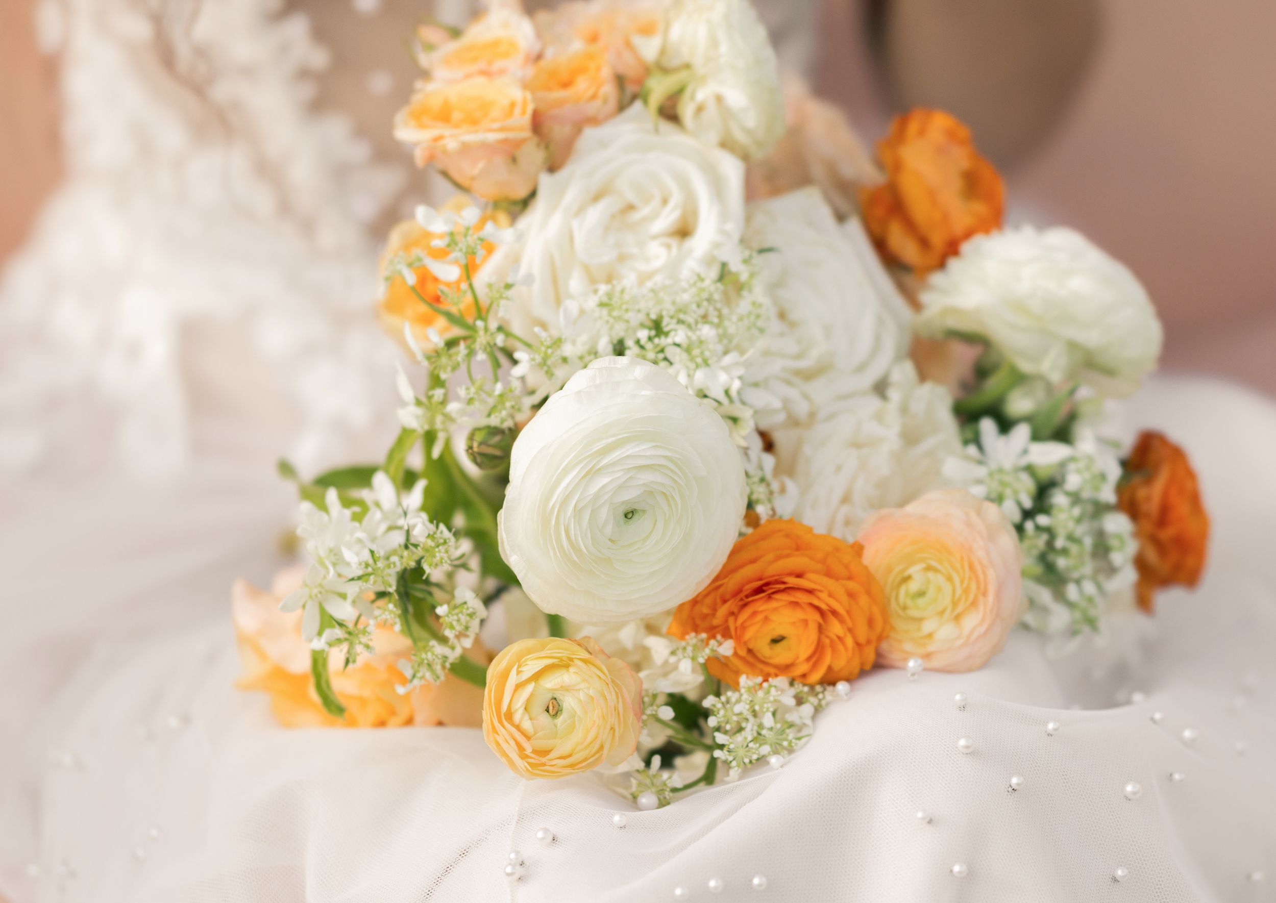 A delicate bridal bouquet featuring white ranunculus, peach roses, Columbus Ohio Wedding Photography.