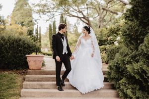 Couple shares romantic moments on garden steps surrounded by lush greenery. Dayton, Ohio.