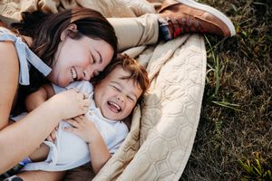 Series of candid photos showing playful moments of a child lying on a blanket outdoors.