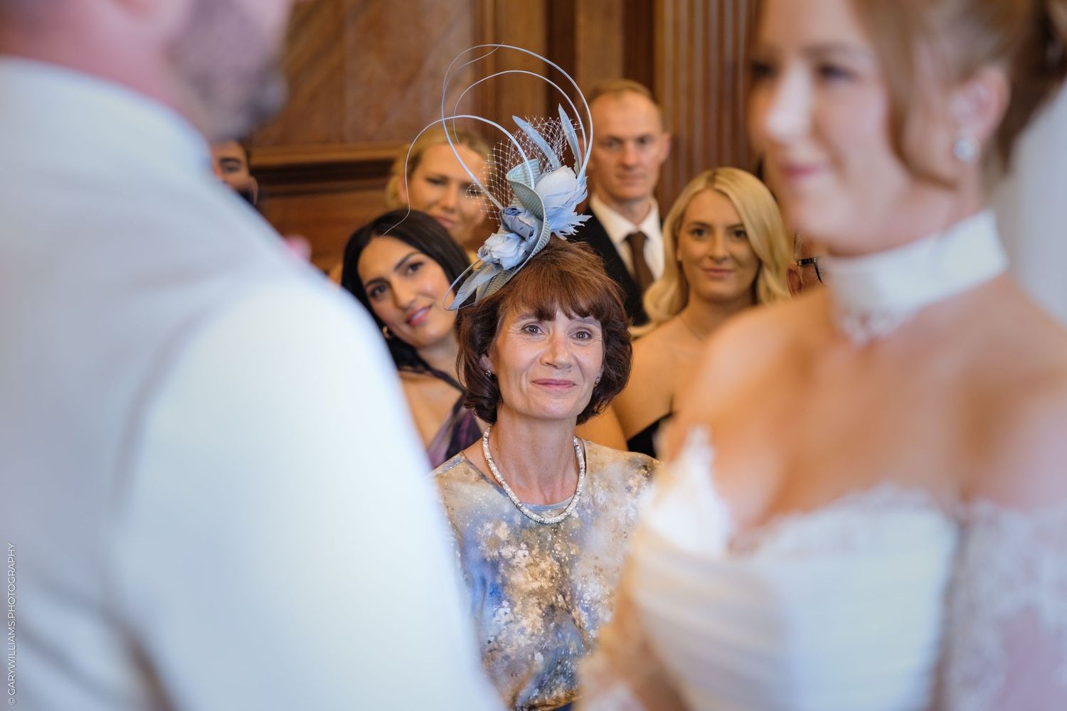 Wedding guests are shown seated and watching attentively during a traditional ceremony.