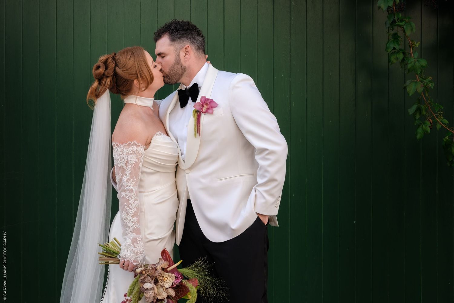 Wedding couple shares intimate moments against rustic dark green wood paneled wall.