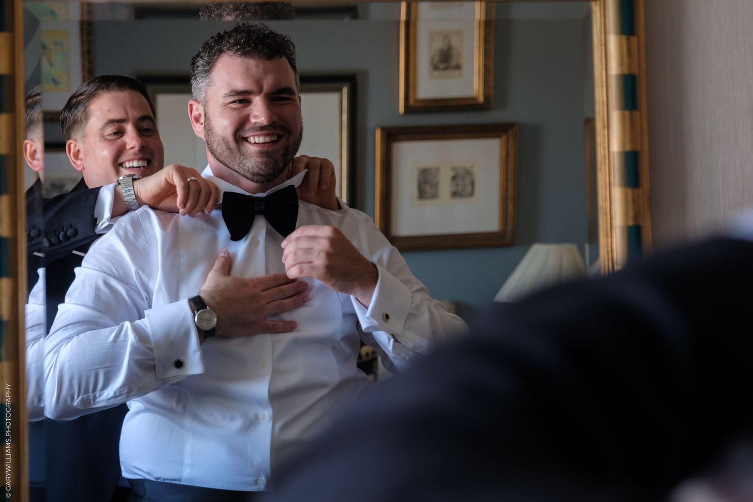 People in white shirts laughing and smiling during a casual gathering in an interior space.