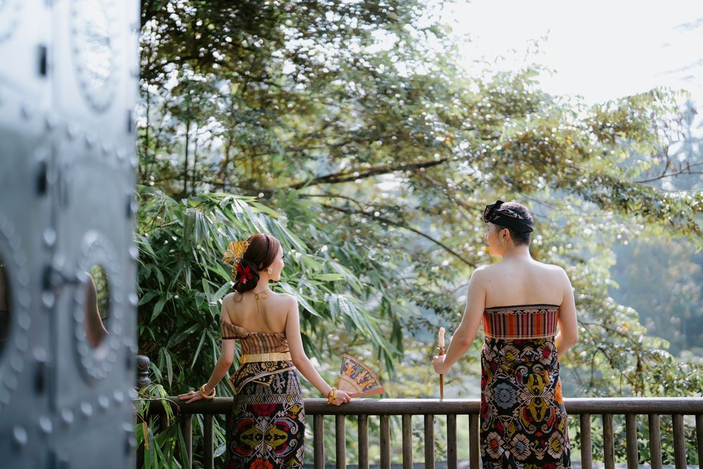Scenic outdoor photoshoot on a misty mountain deck with tropical forest backdrop.