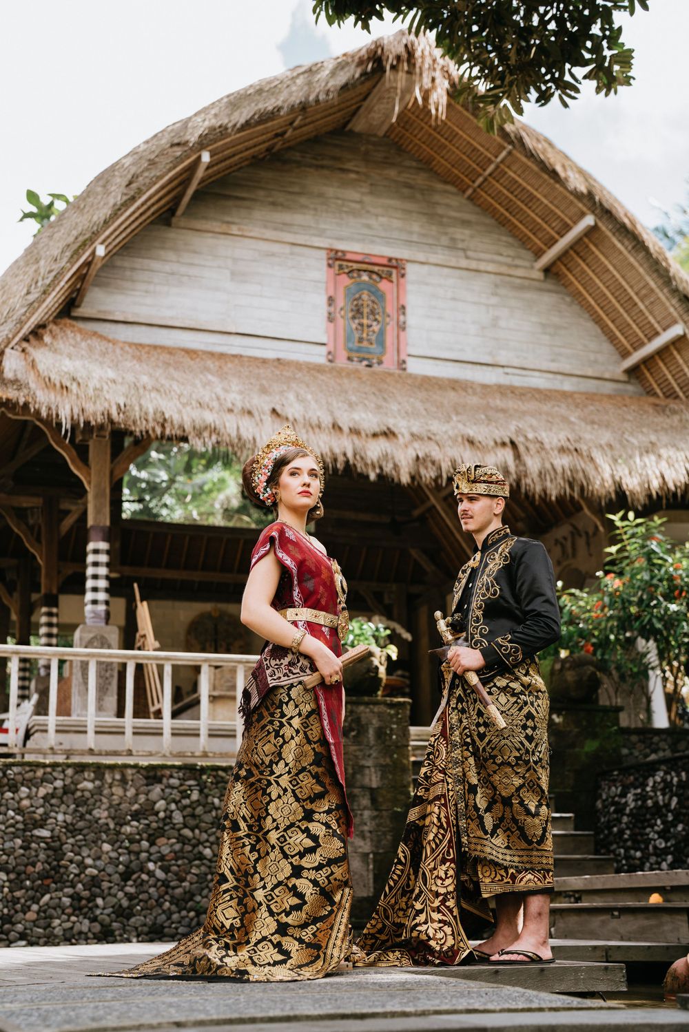 Traditional wedding photography at a thatched-roof Indonesian pavilion.