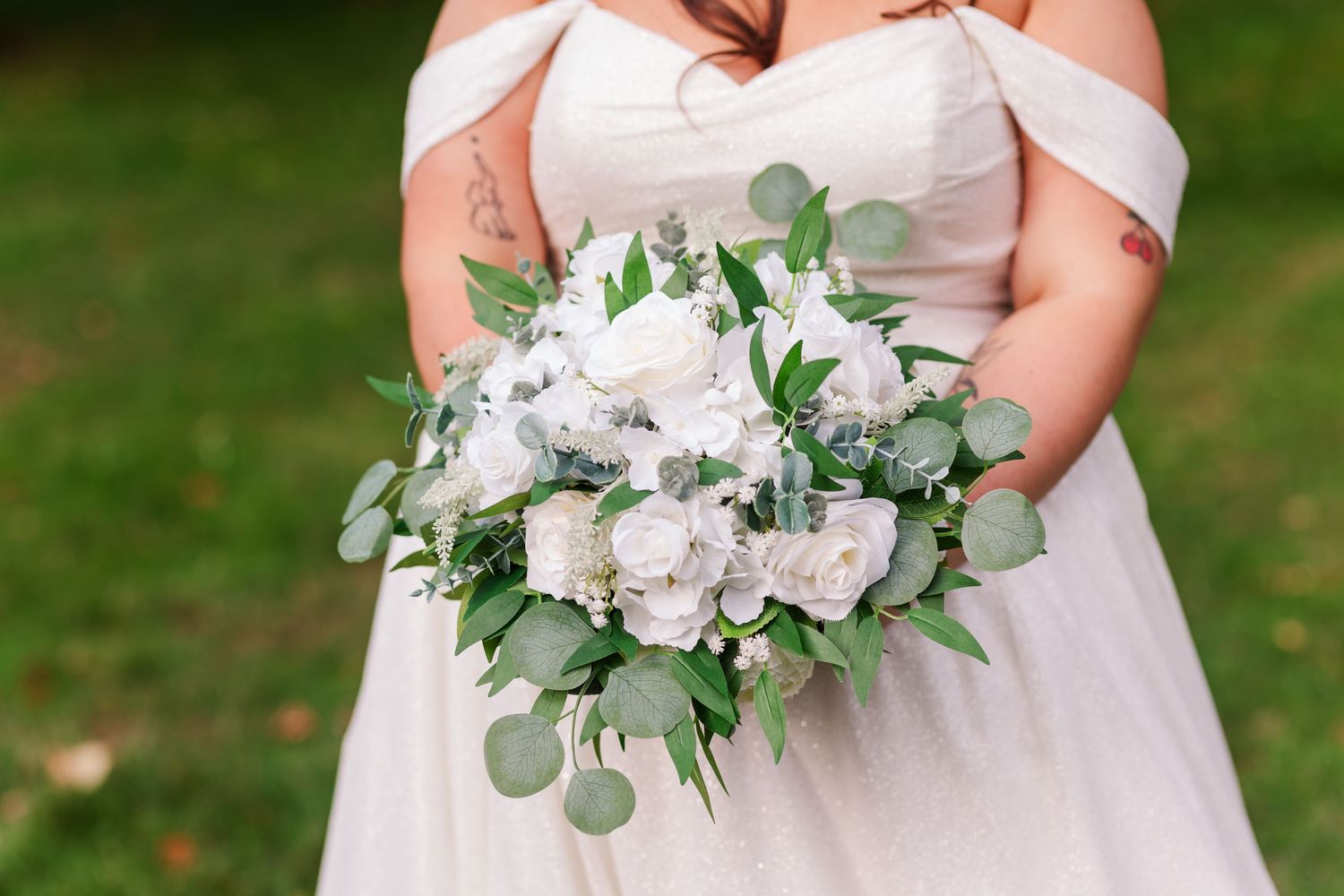 Three elegant white and eucalyptus wedding bouquets arranged in a row showcasing delicate floral design and greenery.