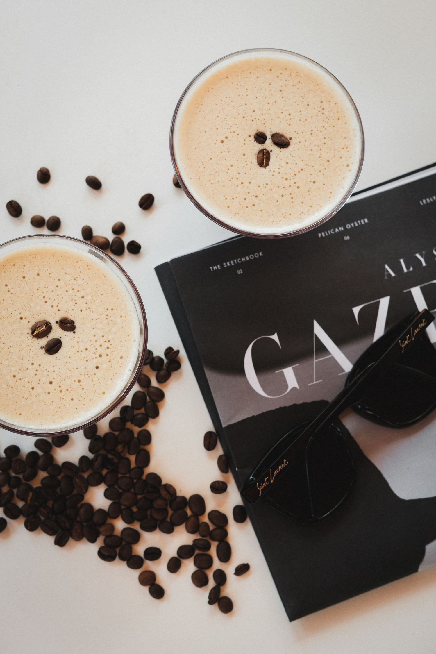 Coffee martinis with scattered coffee beans and elegant black menu cards.