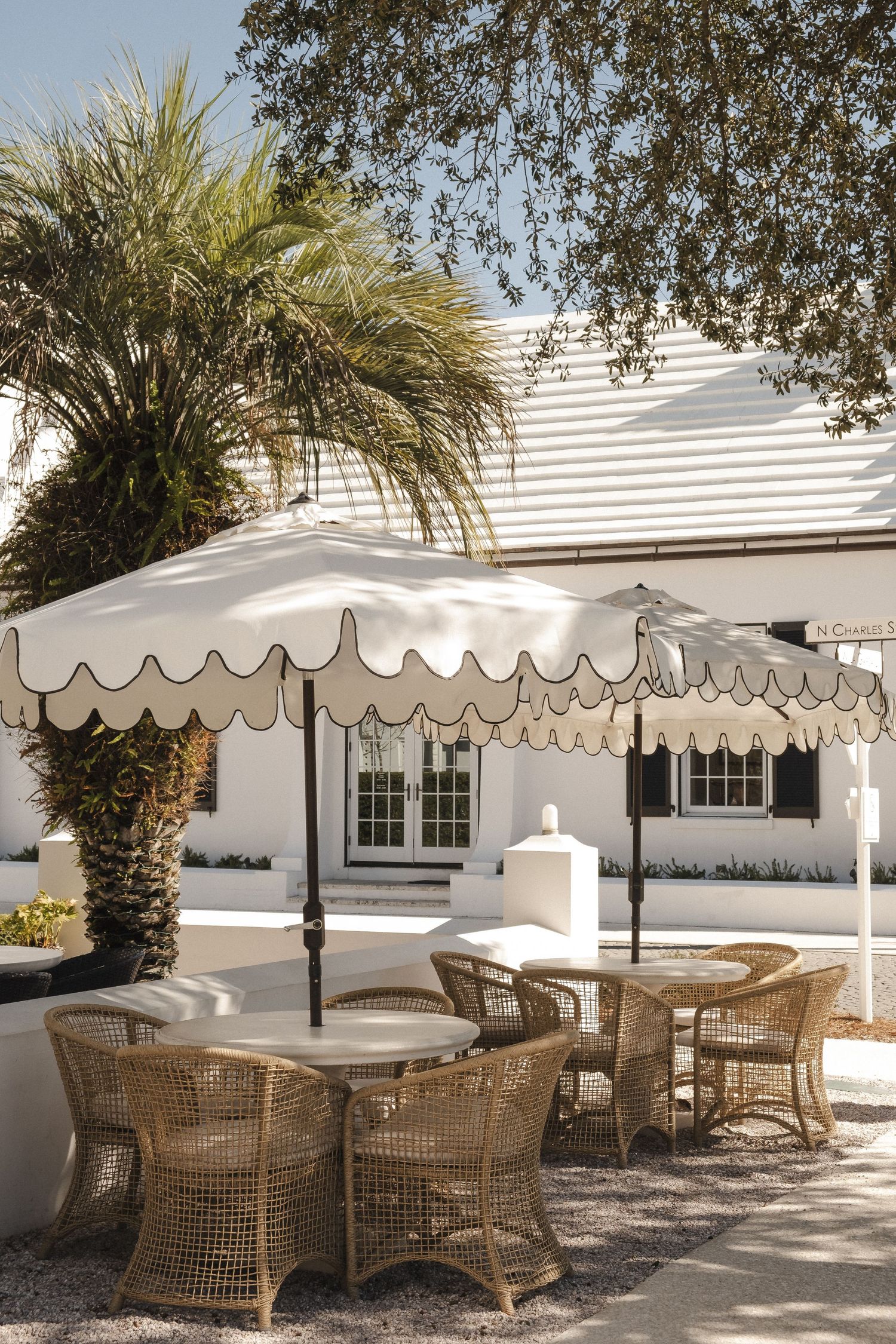 Outdoor patio area with wicker furniture and white scalloped awnings.