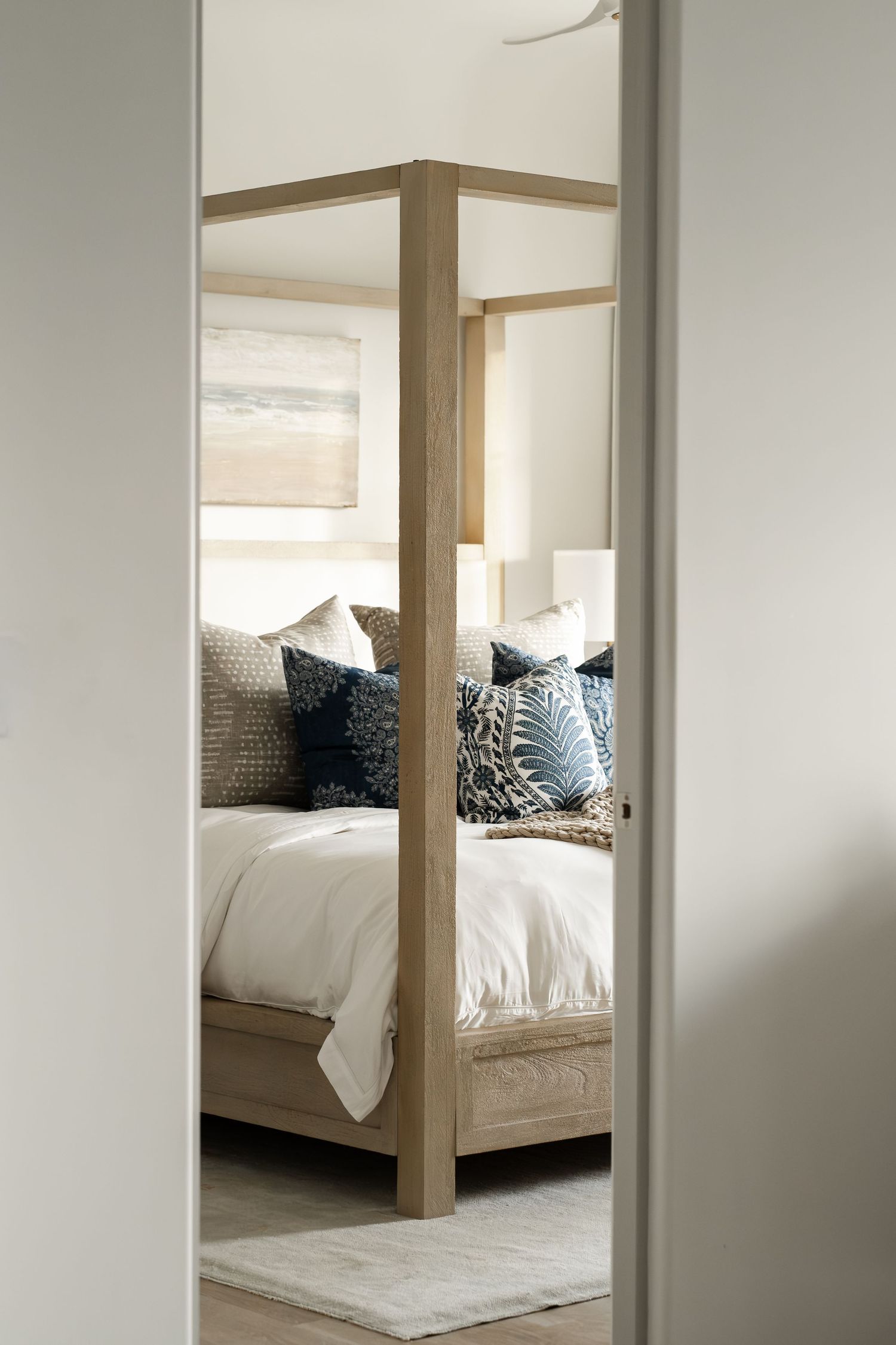 Modern bedroom interior with white bedding and wooden bed frame.