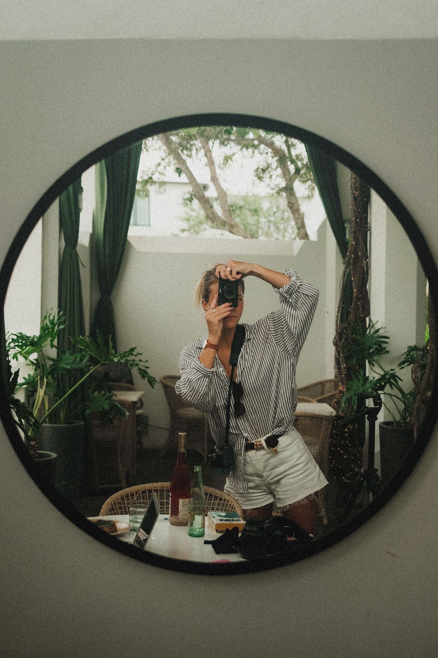 Mirror reflection sequence showing someone stretching or dancing in an indoor garden setting.