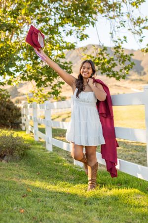 A playful moment by a white fence showing joy and movement with a burgundy shawl.