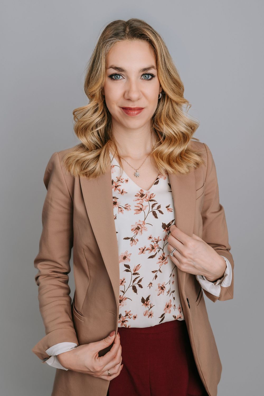 Professional studio portraits showing a tan blazer paired with a floral top and burgundy skirt in various poses.