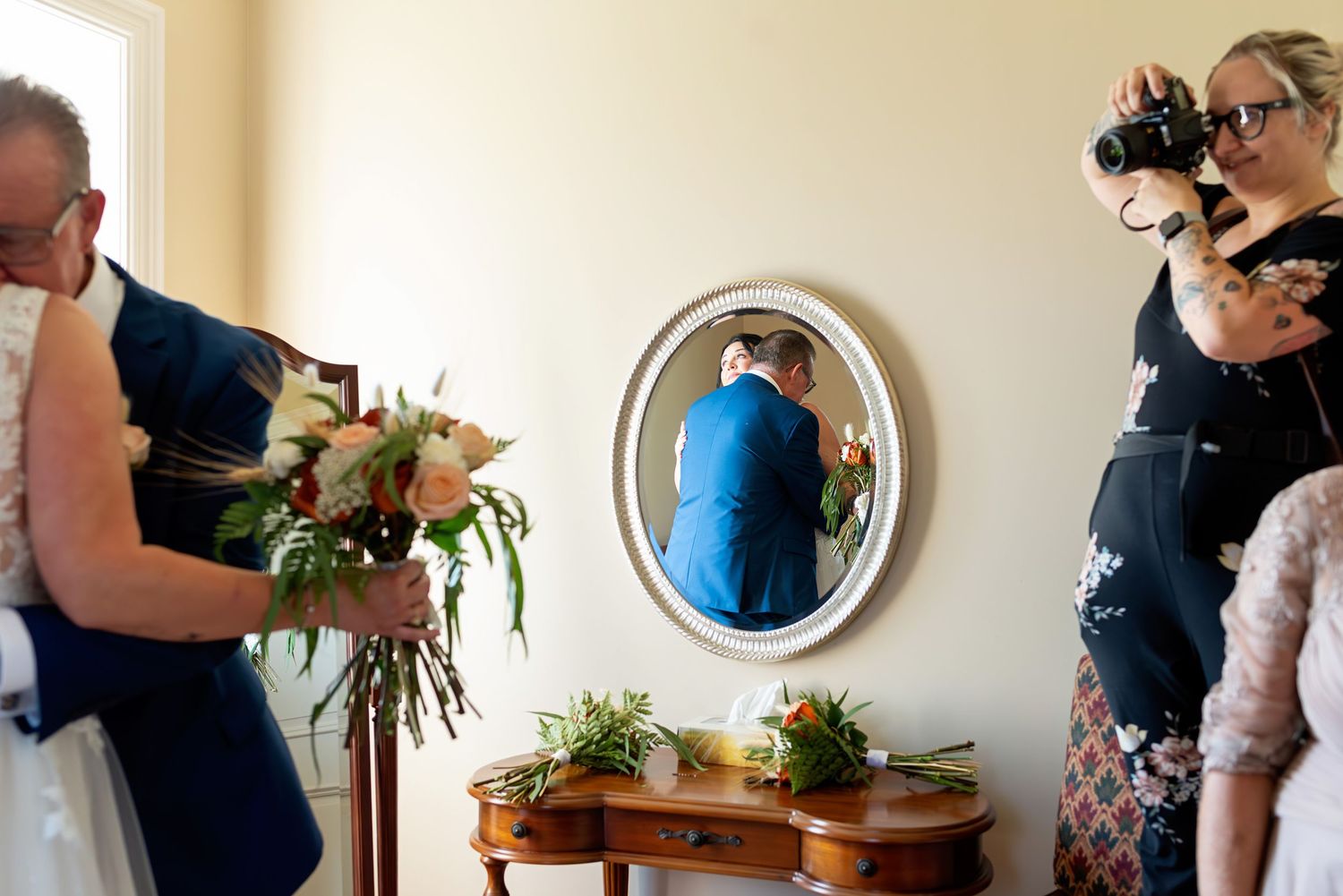 Emotional celebration moment captured indoors with decorative wall mirrors at the Rose Chapel.