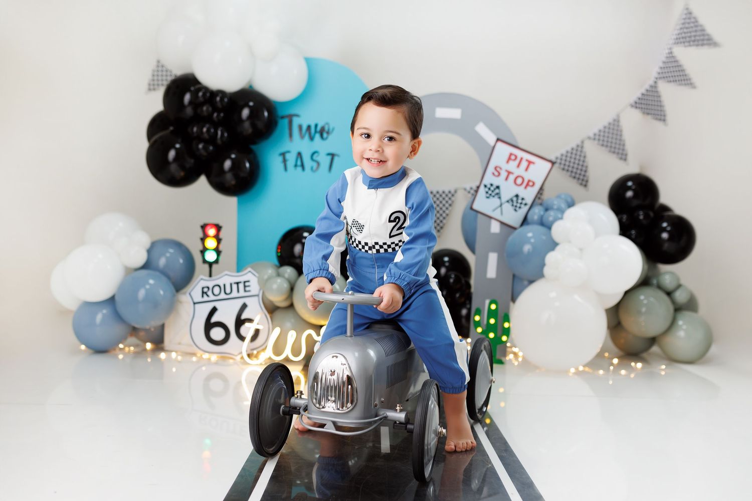 Two year birthday celebration setup with blue and black balloons, bunting, and Route 66 themed decorations.