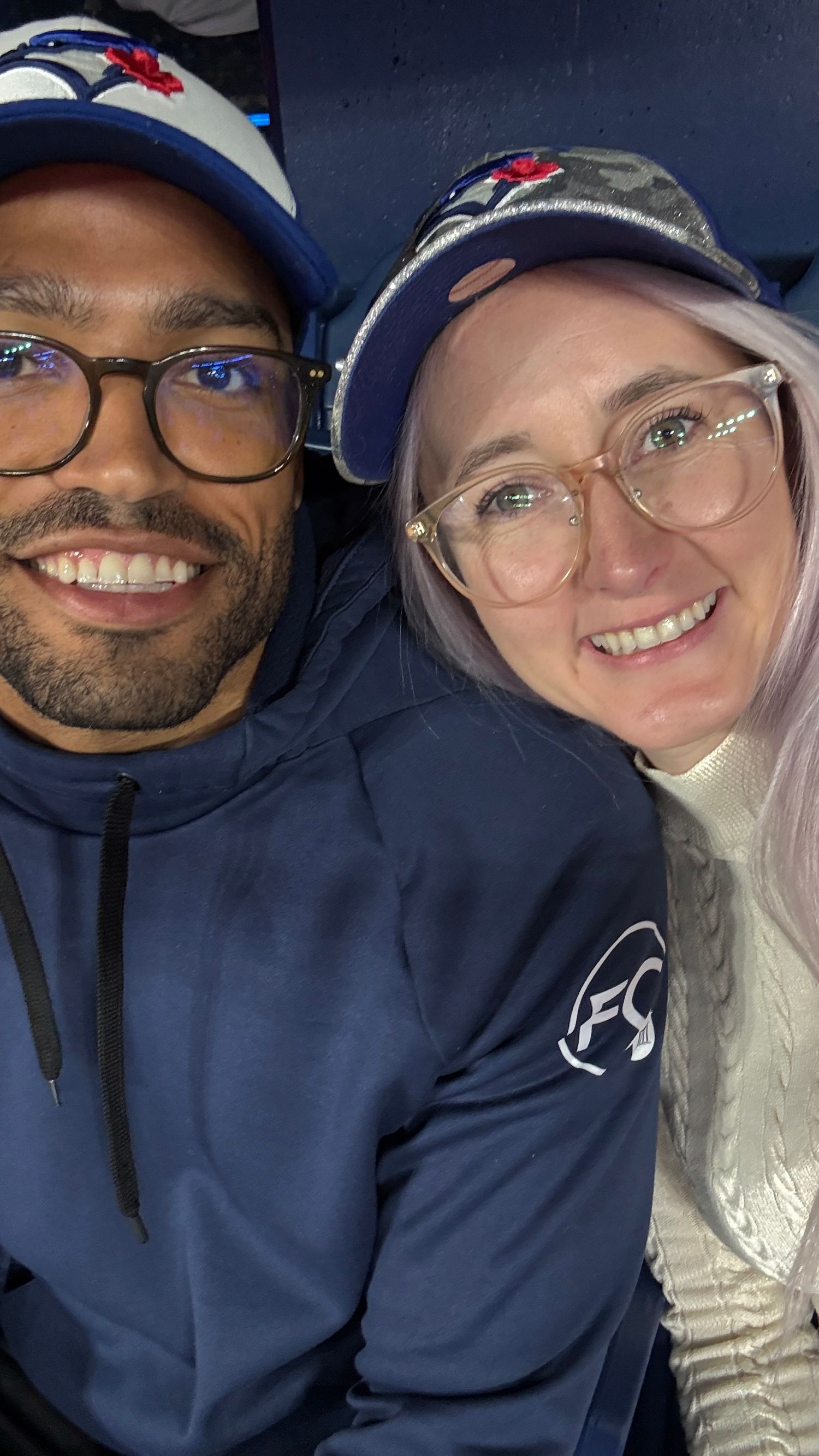 A series of selfies showing a couple in blue hoodies smiling together in a dark setting.