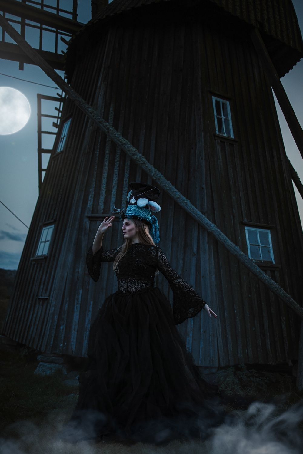 Spooky moonlit scene with an old wooden barn or windmill structure casting dramatic shadows in misty darkness.