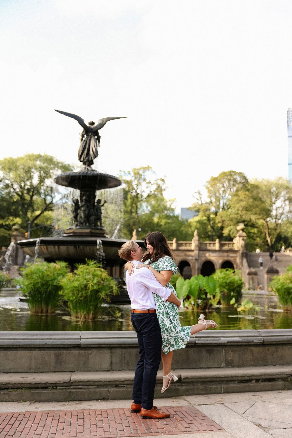 A romantic moment shared in front of a historic fountain in Central Park during an autumn afternoon.