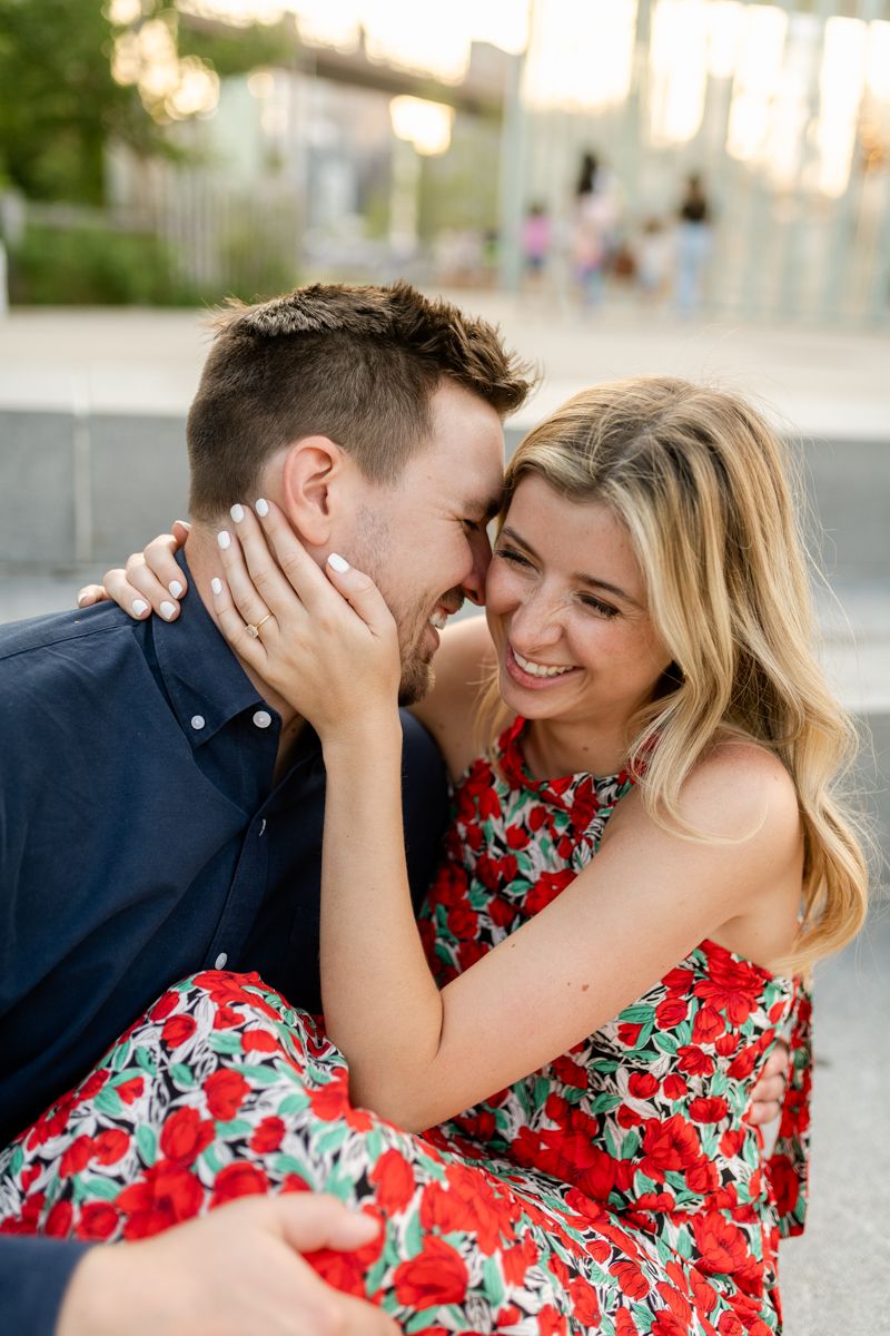 Intimate couple sharing joyful moment together outdoors in floral dress and navy shirt.
