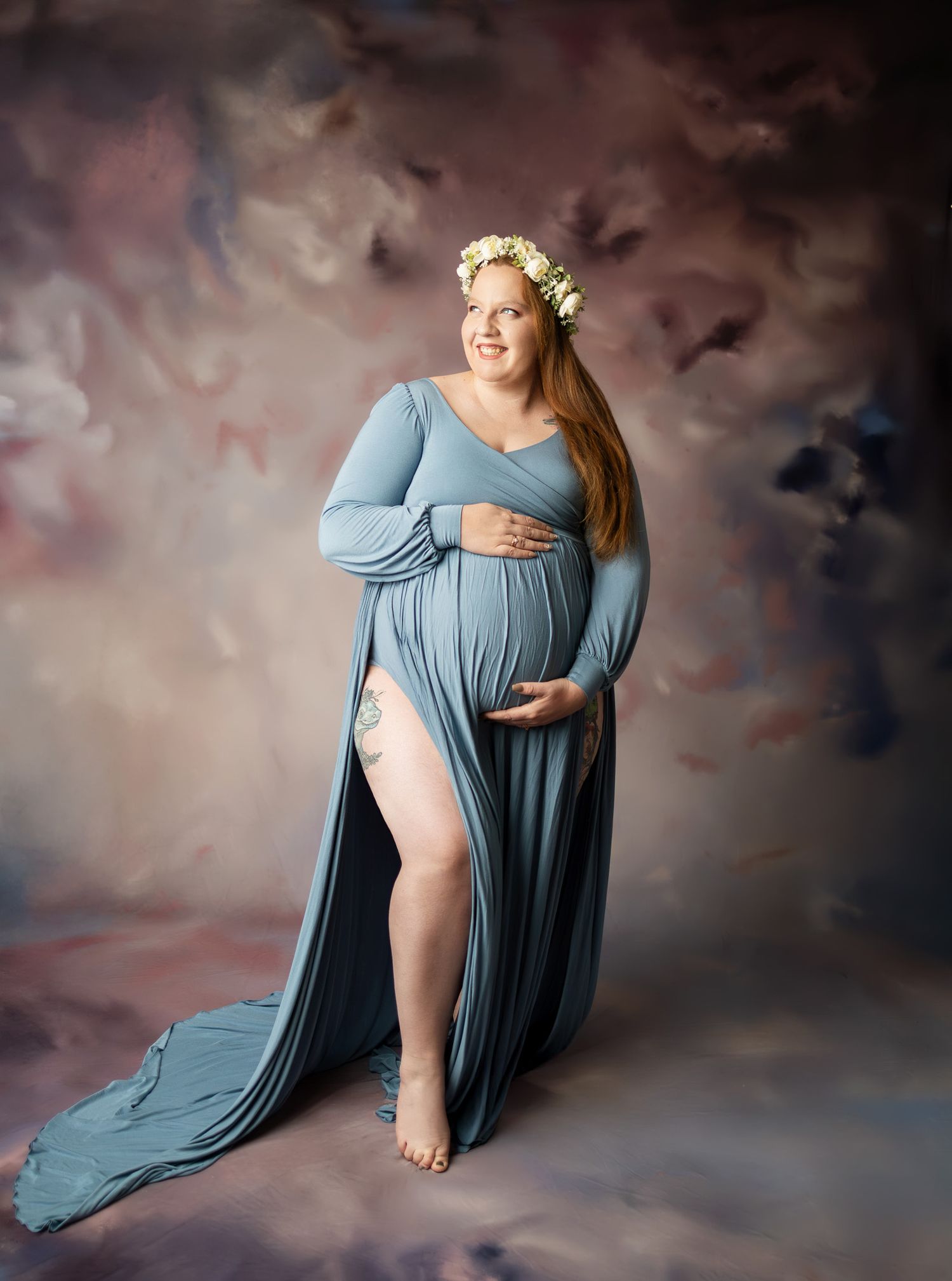 A series of maternity portraits showing a woman in a flowing blue dress against a moody clouded backdrop.