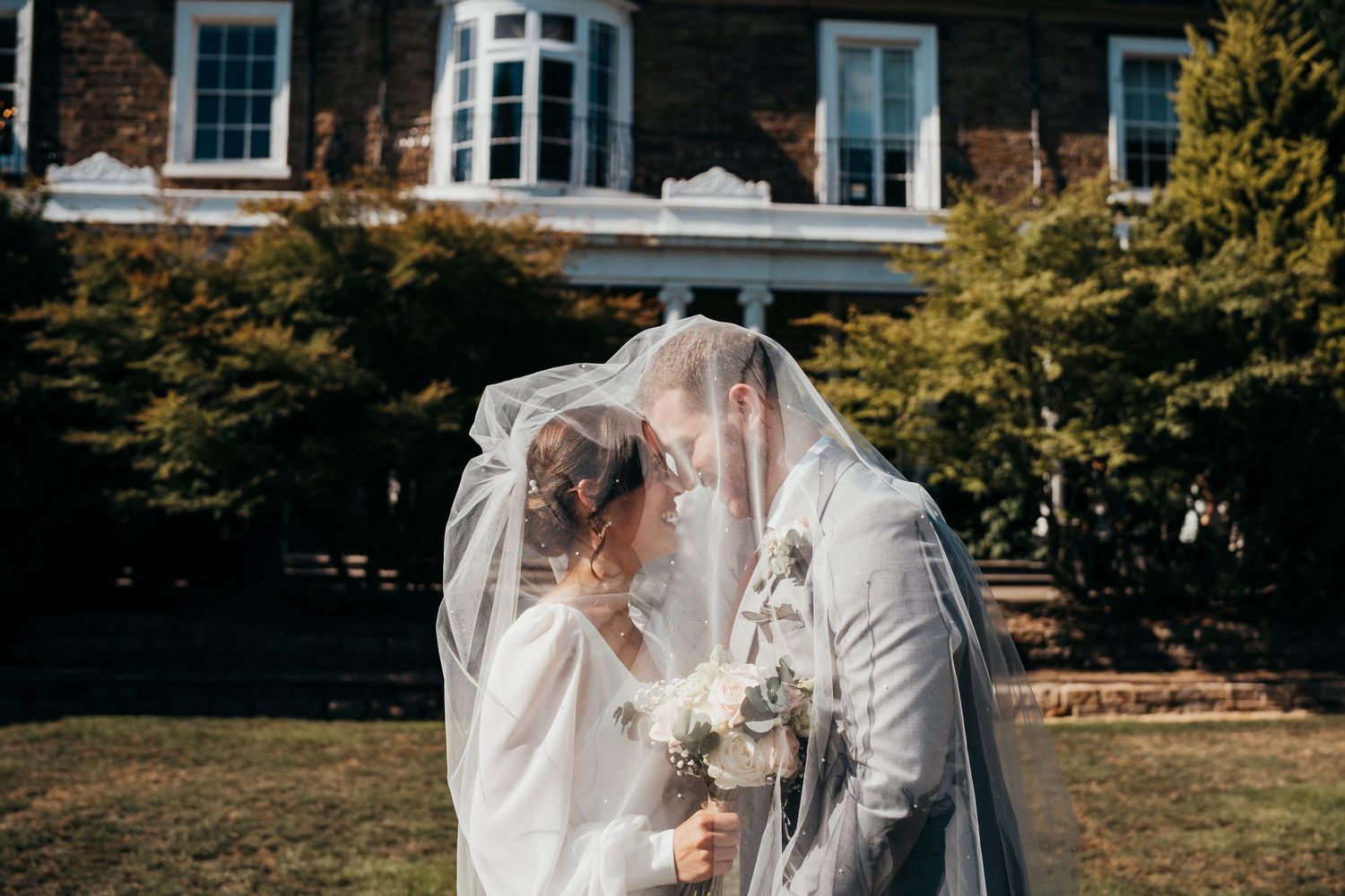 Series of romantic wedding photos taken in front of a traditional house with bay windows.