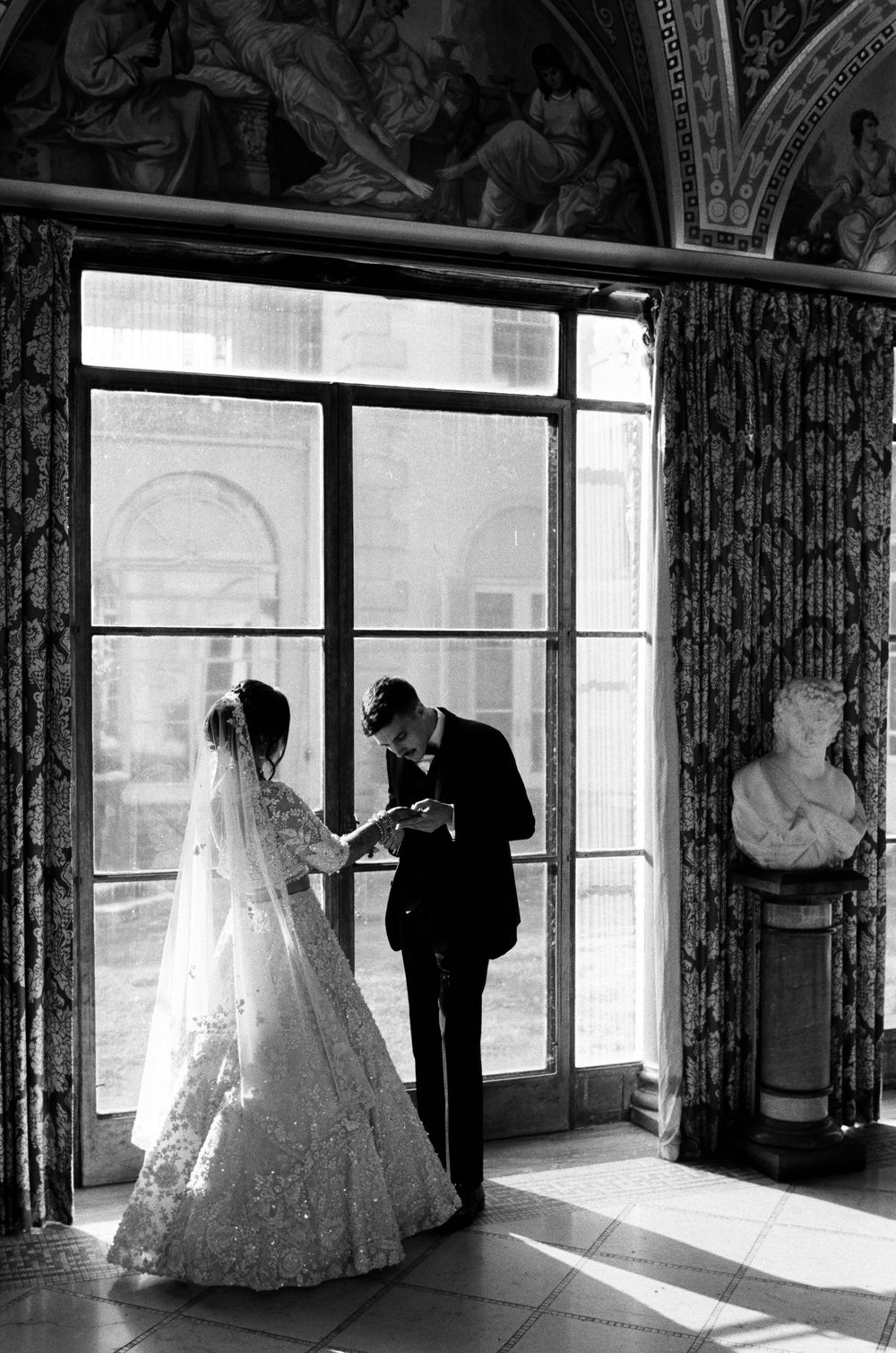 A groom searches for his name in brides henna at Cuneo Mansion.