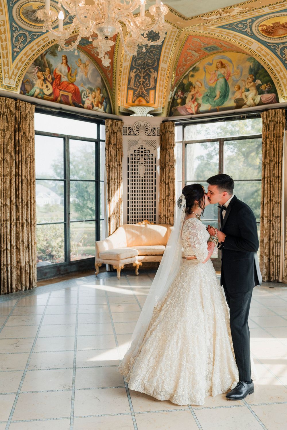 A bride and groom kiss during their first look in the Cuneo Mansion's Formal Dining room.