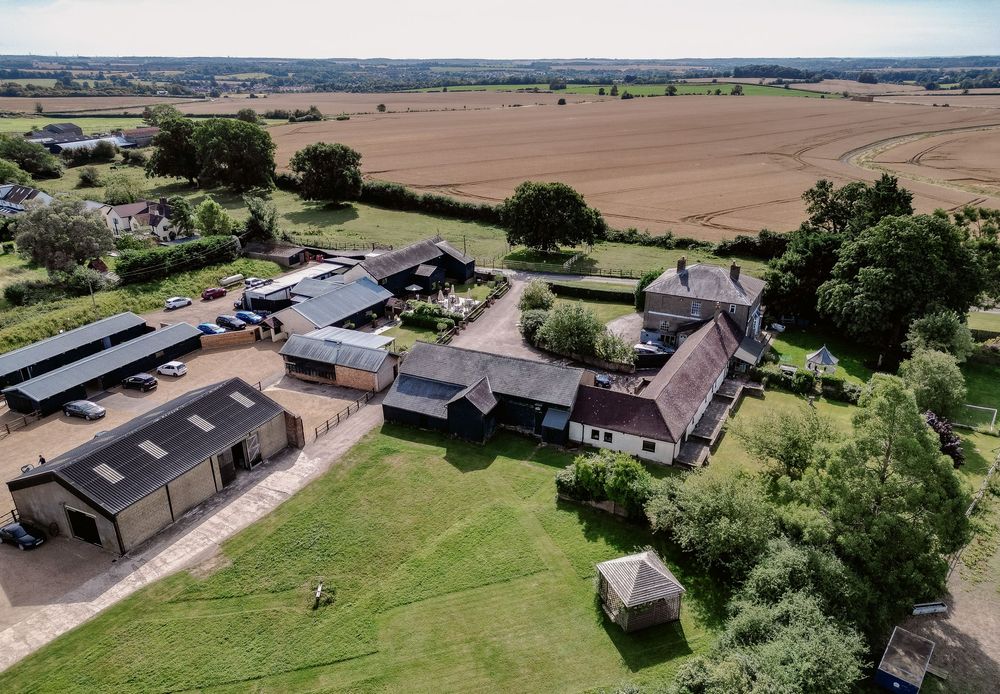 Aerial view of a large rural property with multiple buildings and landscaped grounds.