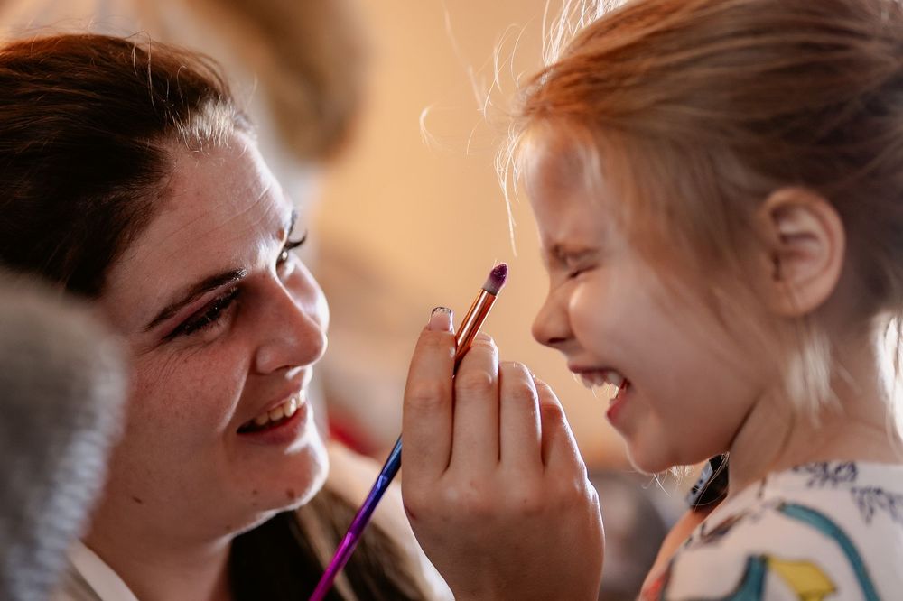 Intimate moment of face painting during a festive celebration.
