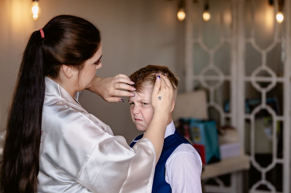 A medical professional checks a patient's forehead in an office setting with warm lighting and decorative elements.