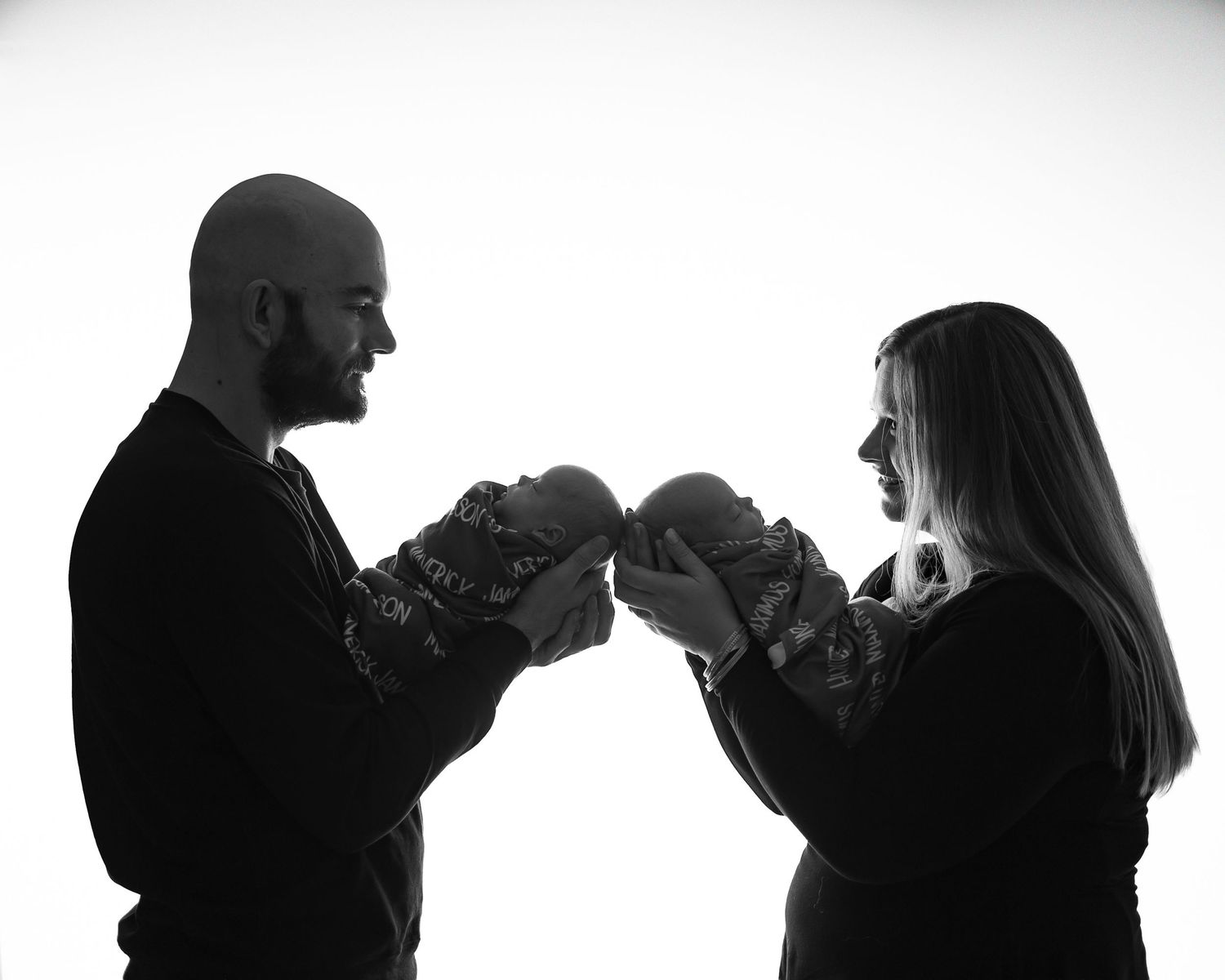 Parents holding their twin newborn babies during a studio photo session in Michigan