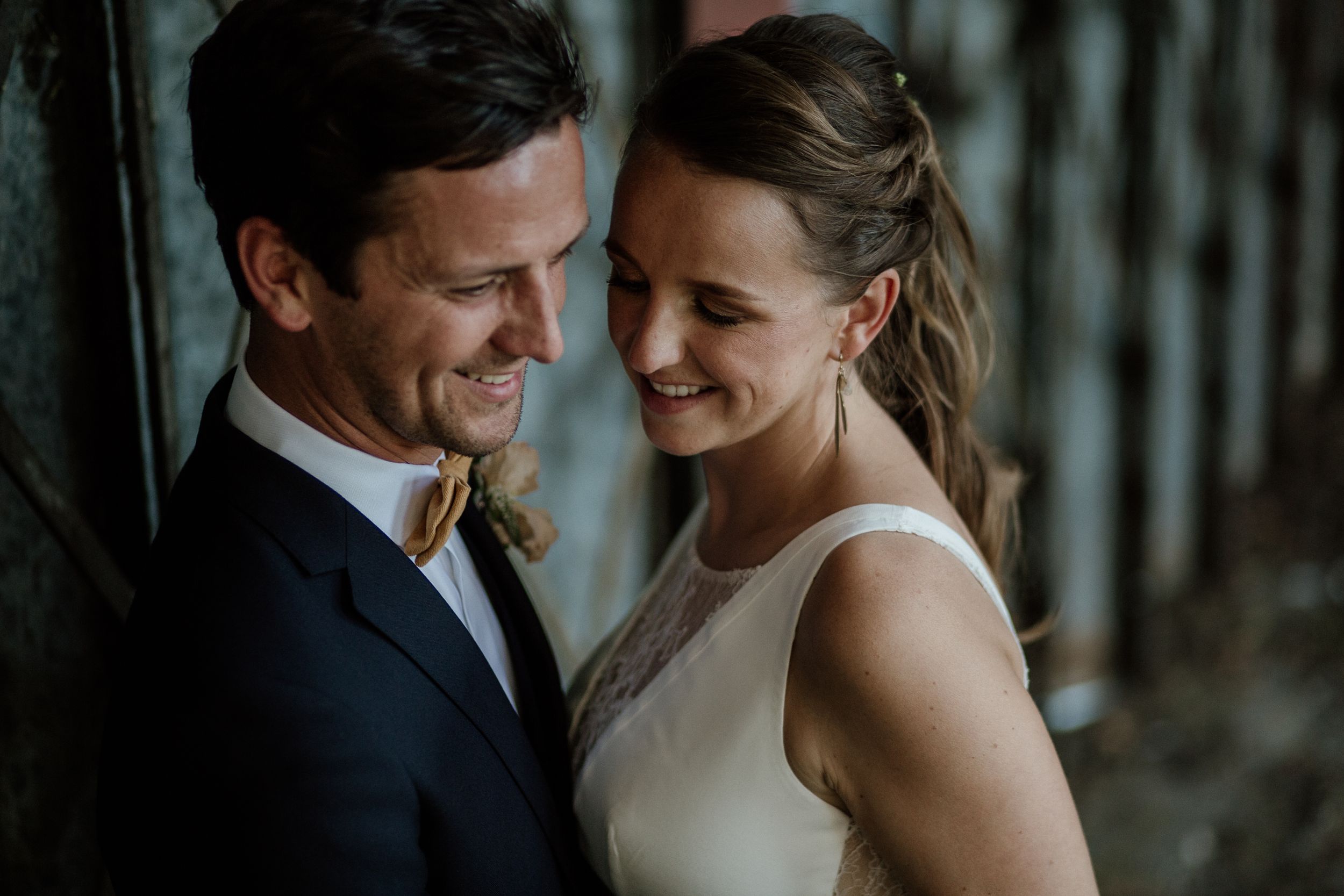 Indoor wedding portraits with dramatic lighting showcasing tender moments between newlyweds.