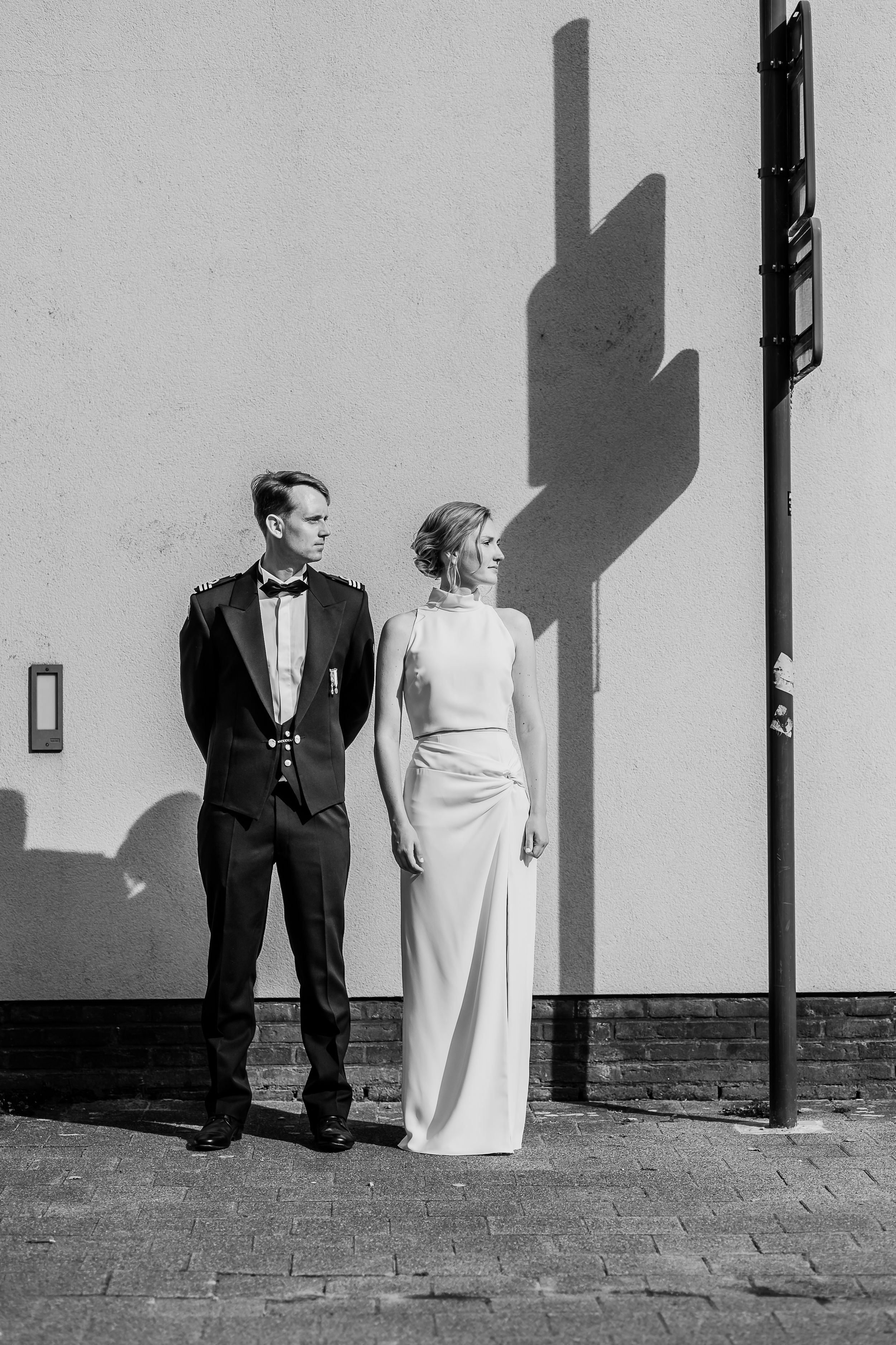 Black and white artistic portrait showing shadows of a couple against a white wall.